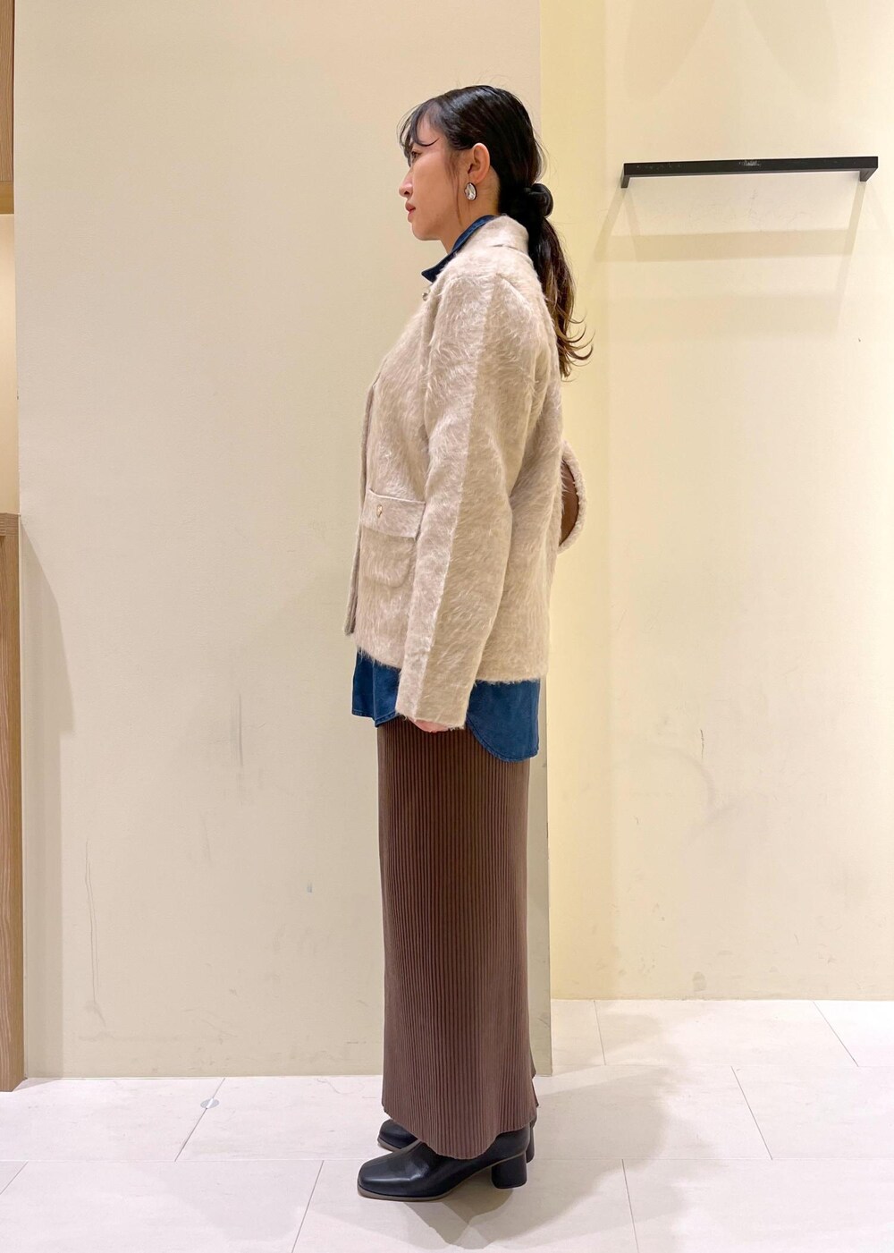 ブルー系のシャツ/ブラウス、ベージュ系のカーディガン/ボレロ、ブラック系のブーツを着用したレディースの秋コーディネートの4枚目の写真