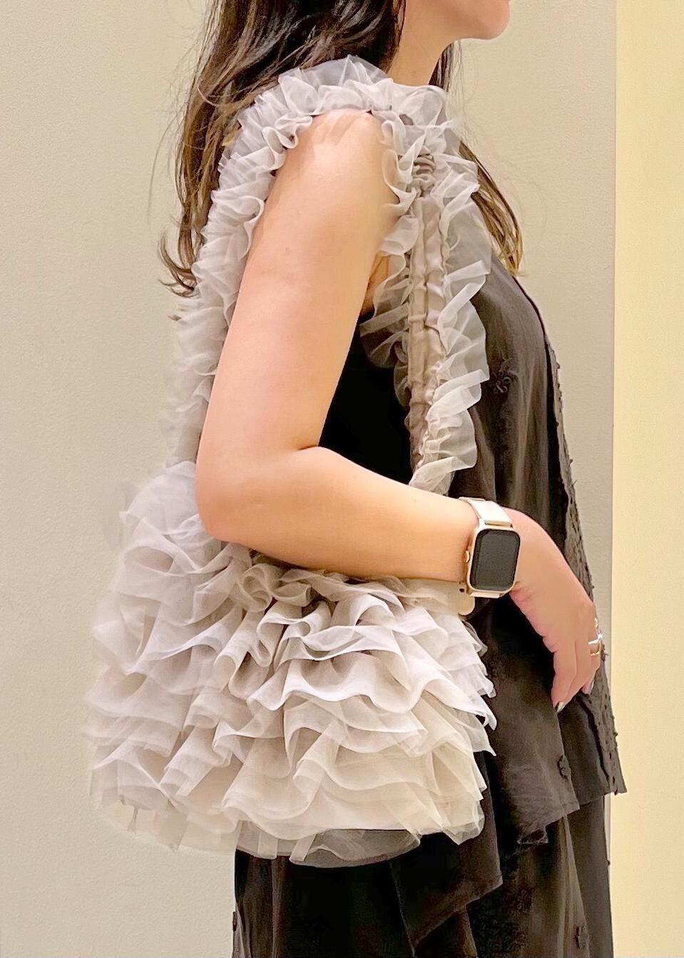 ベージュ系のショルダーバッグ、ゴールド系のサンダル、ブラック系のシャツ/ブラウスを着用したレディースの夏コーディネートの9枚目の写真