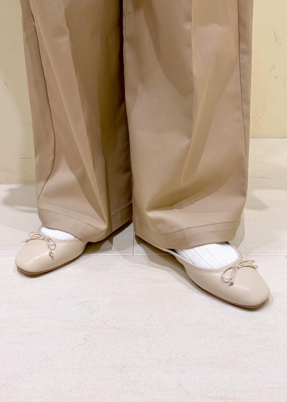 ホワイト系のバレエシューズ、イエロー系のショルダーバッグ、ベージュ系のチノパンツを着用したレディースの冬コーディネートの10枚目の写真