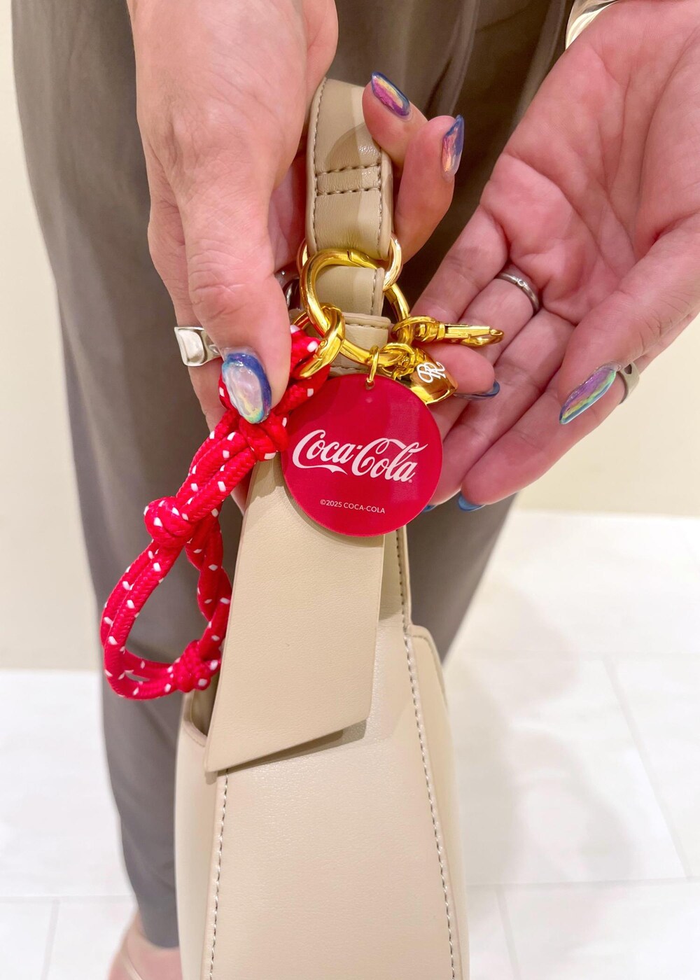 ゴールド系のサンダル、ベージュ系のハンドバッグ、グレー系のTシャツ/カットソーを着用したレディースの夏コーディネートの9枚目の写真