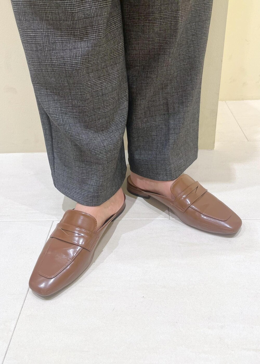 ブラウン系のベスト、ホワイト系のTシャツ/カットソー、グレー系のスラックスを着用したレディースの秋コーディネートの9枚目の写真