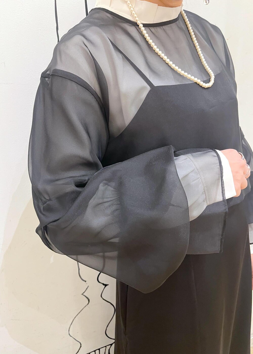 ベージュ系のローファー、ホワイト系のショルダーバッグ、ブラック系のドレスを着用したレディースの冬コーディネートの5枚目の写真