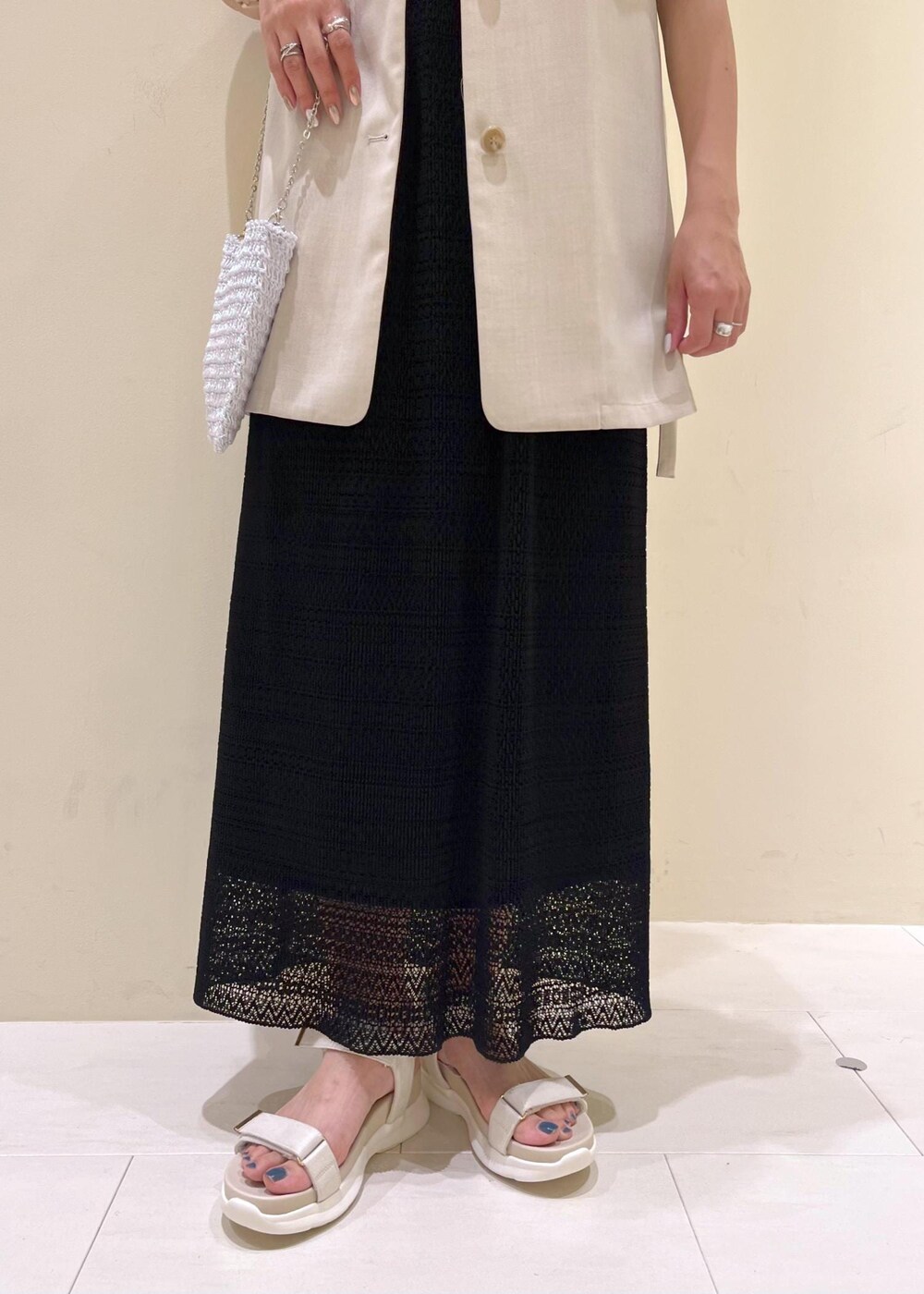 その他のショルダーバッグ、ベージュ系のベスト、ホワイト系のサンダルを着用したレディースの春コーディネートの8枚目の写真