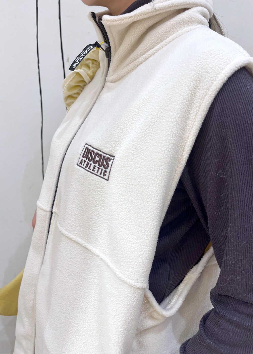 グレー系のTシャツ/カットソー、ブラック系のレインシューズ、イエロー系のショルダーバッグを着用したレディースの秋コーディネートの5枚目の写真