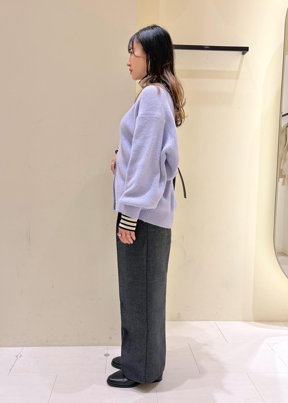 ブラック系のショルダーバッグ、ホワイト系のニット/セーター、グレー系のスラックスを着用したレディースの冬コーディネートの5枚目の写真