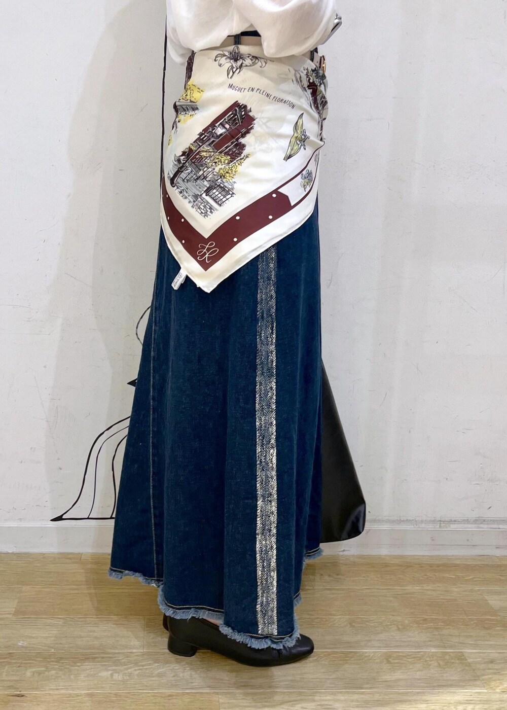 ブラック系のパンプス、ブラック系のトートバッグ、ブルー系のデニムスカートを着用したレディースの秋コーディネートの8枚目の写真