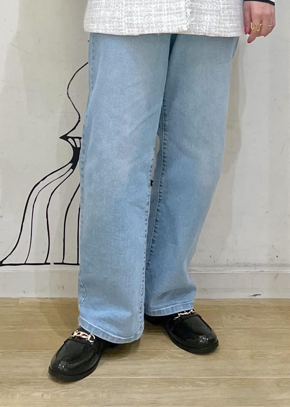 ホワイト系のニット/セーター、ブルー系のデニムパンツ、ブラック系のレインシューズを着用したレディースの冬コーディネートの9枚目の写真