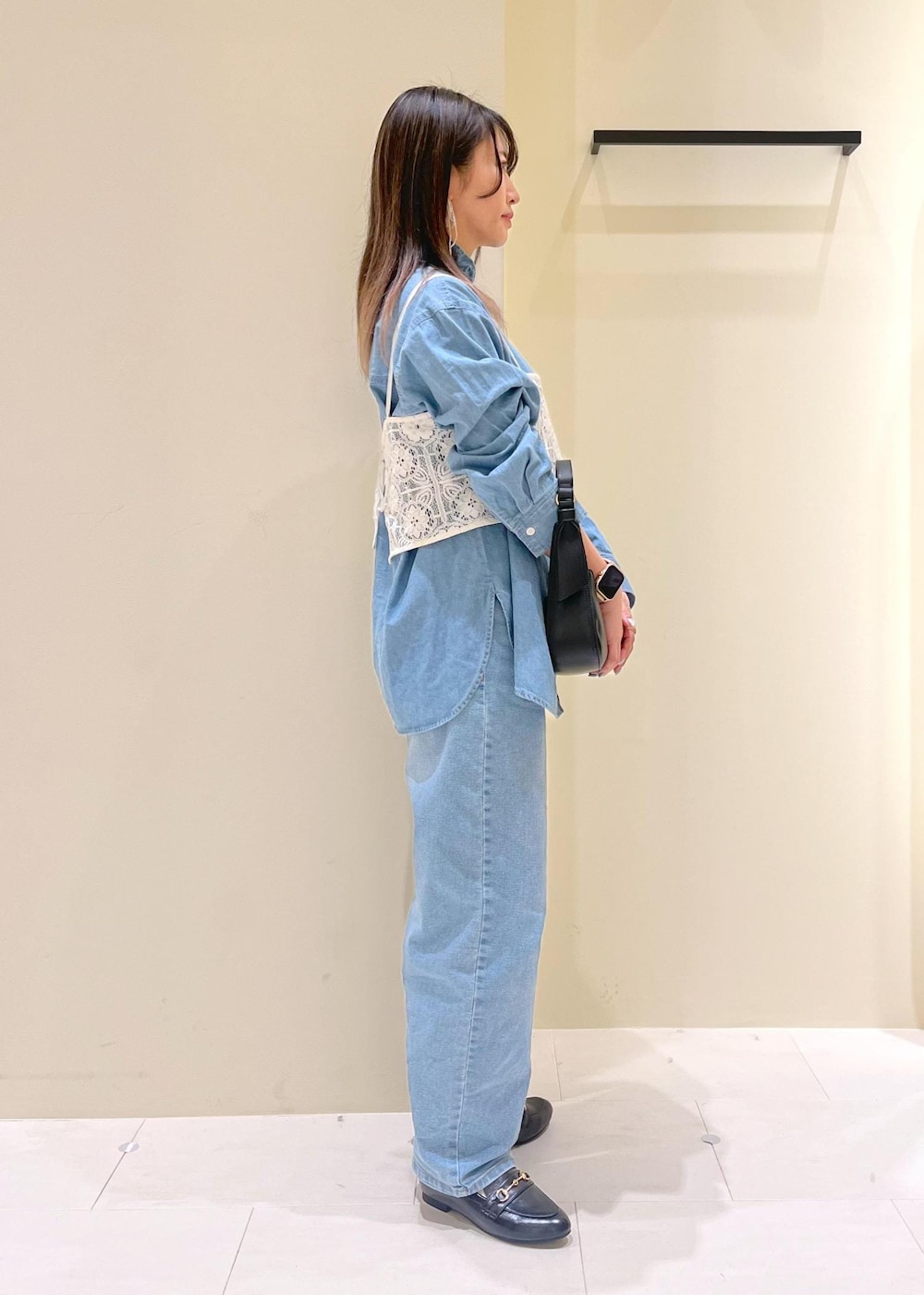 ブルー系のデニムパンツ、ホワイト系のキャミソール、ブラック系のハンドバッグを着用したレディースの春コーディネートの3枚目の写真