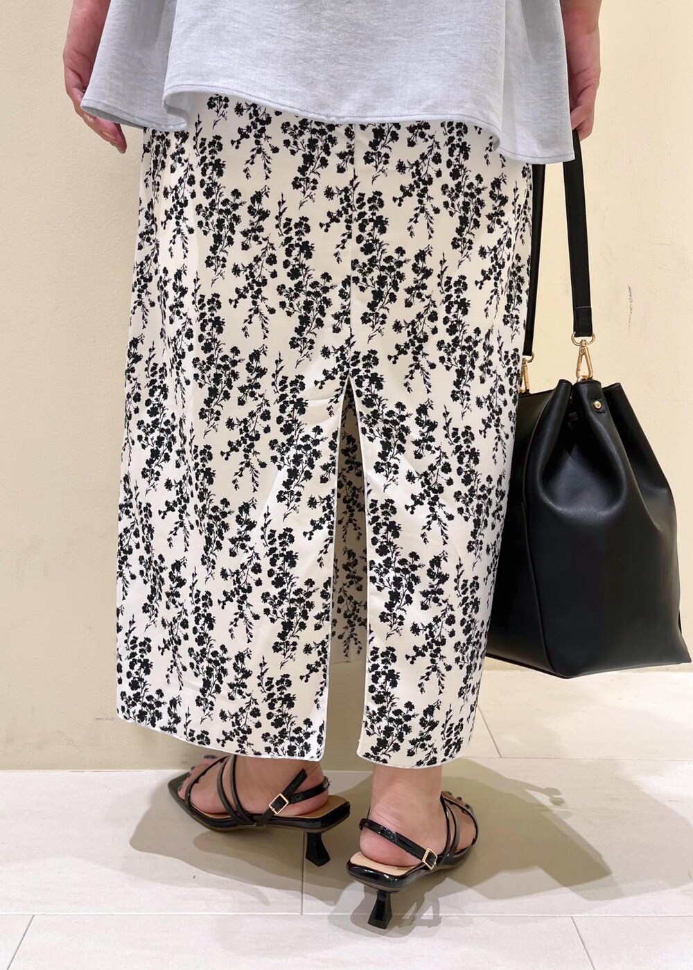 ブラック系のサンダル、ホワイト系のスカート、ブラック系のショルダーバッグを着用したレディースの夏コーディネートの8枚目の写真