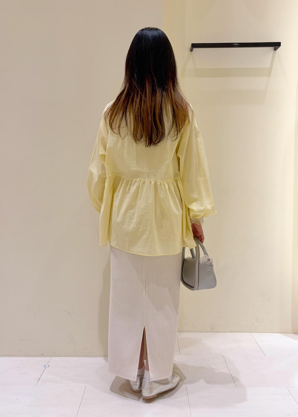 ホワイト系のTシャツ/カットソー、シルバー系のショルダーバッグ、ホワイト系のスカートを着用したレディースの春コーディネートの3枚目の写真