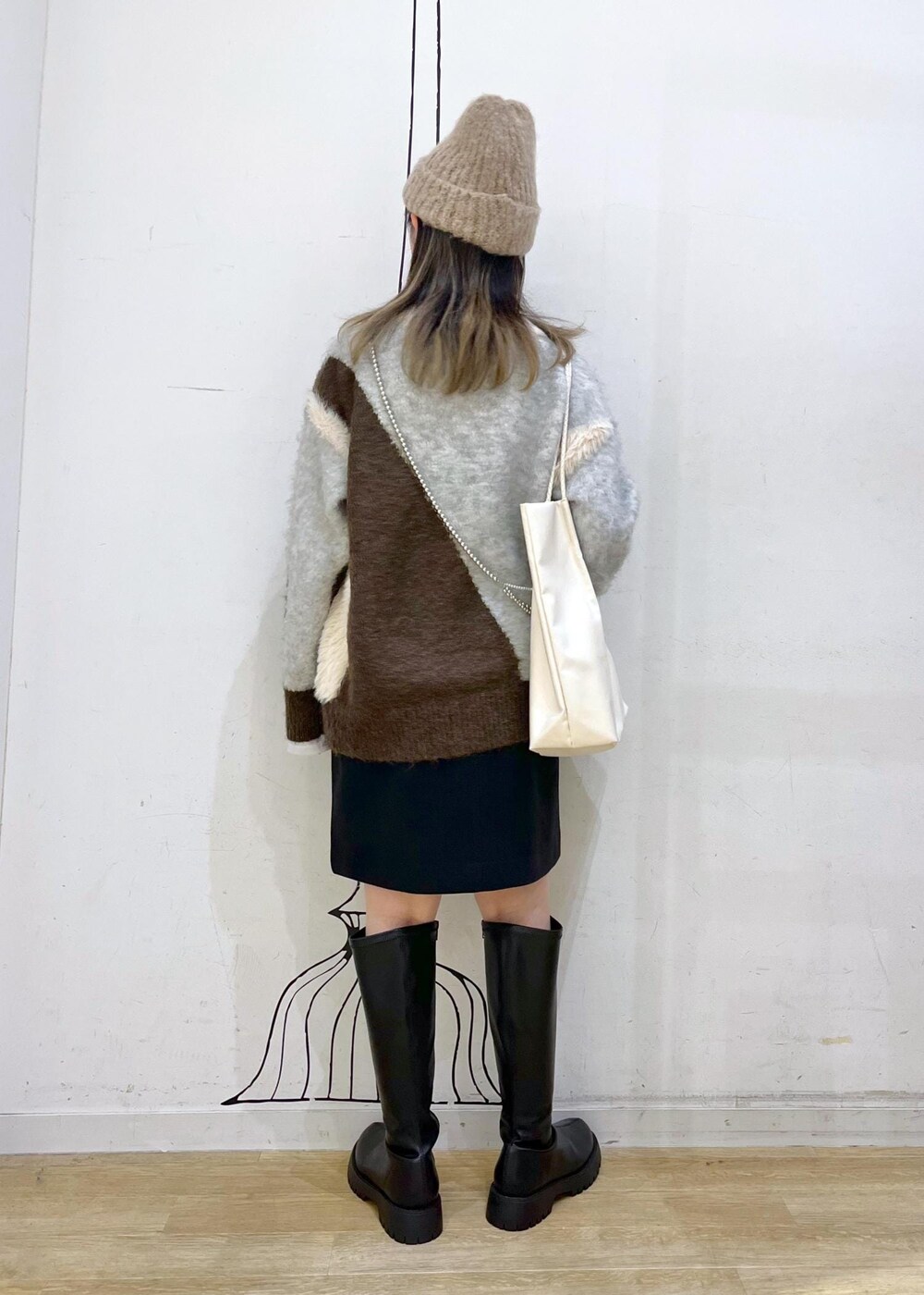ブラック系のスカート、ブラック系のブーツ、ブラウン系のニット/セーターを着用したレディースの秋コーディネートの5枚目の写真