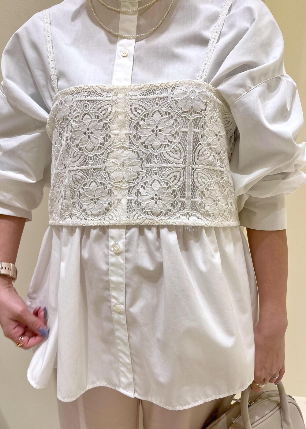 ホワイト系のキャミソール、ホワイト系のシャツ/ブラウス、ベージュ系のボストンバッグを着用したレディースの春コーディネートの5枚目の写真