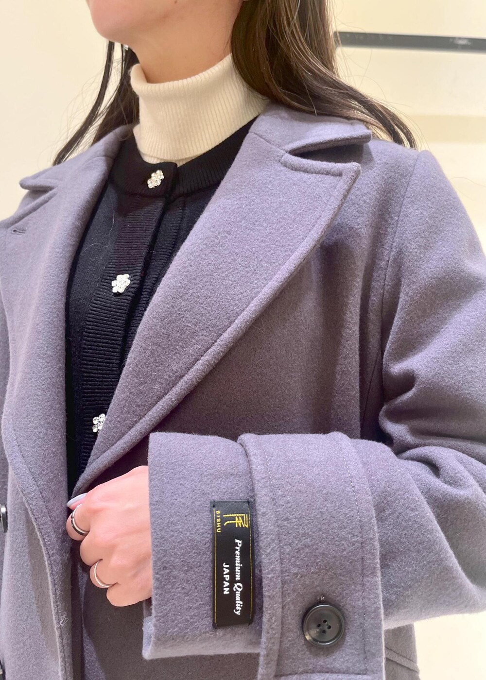 ホワイト系のニット/セーター、グレー系のチェスターコート、レッド系のショルダーバッグを着用したレディースの冬コーディネートの6枚目の写真