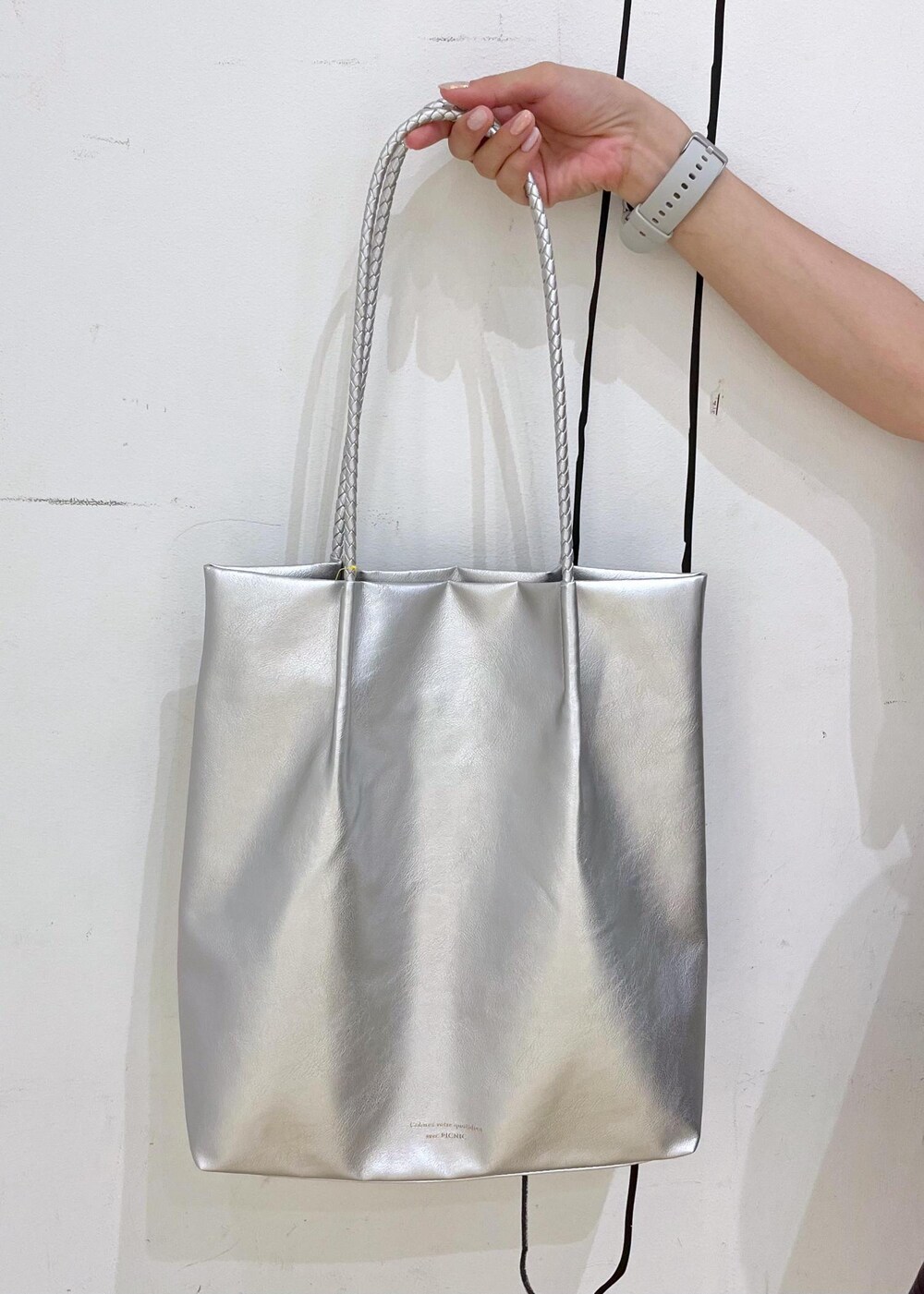 シルバー系のトートバッグ、ブラック系のサンダル、グレー系のTシャツ/カットソーを着用したレディースの夏コーディネートの9枚目の写真