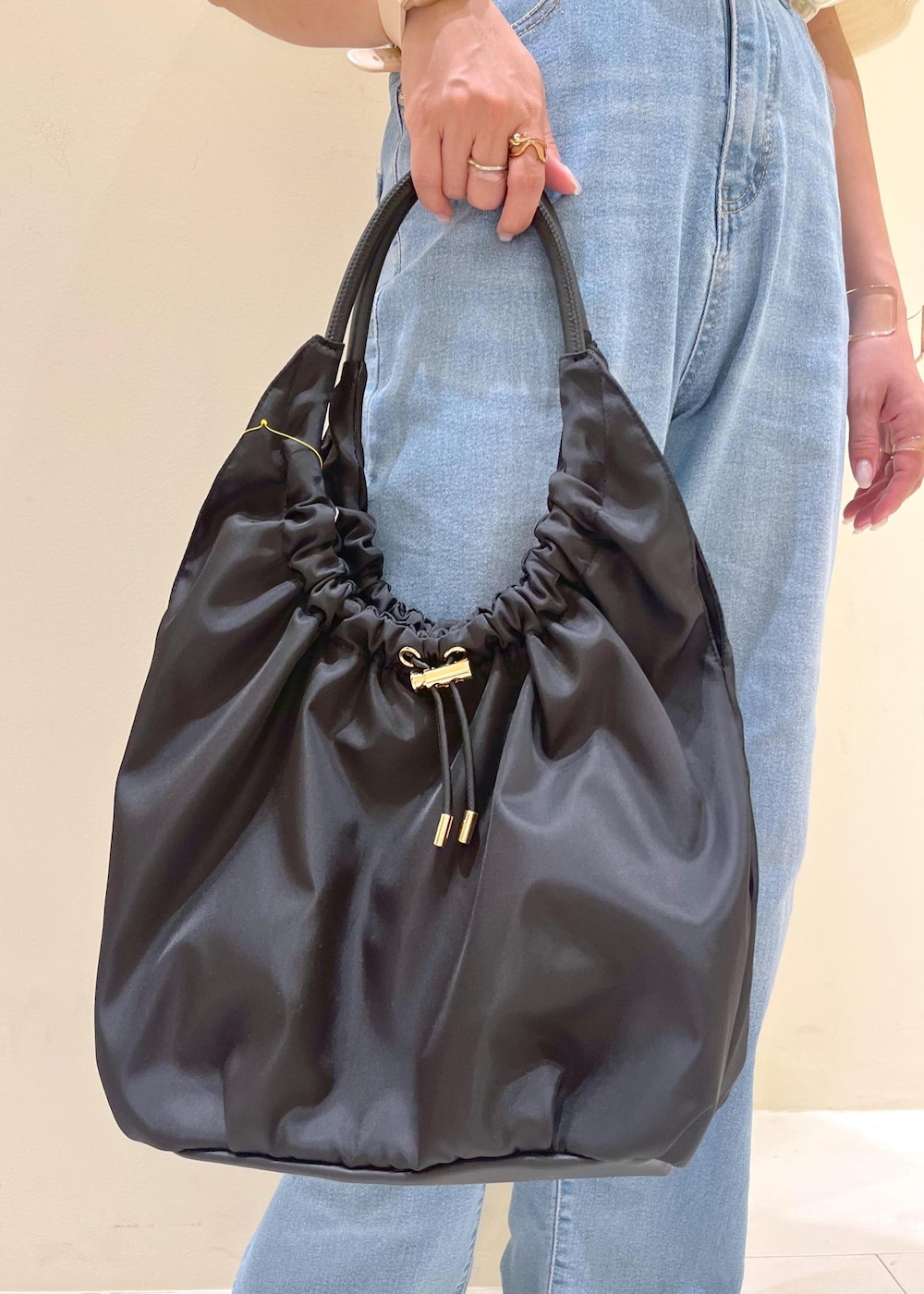 ブルー系のデニムパンツ、ホワイト系のニット/セーター、ブラック系のサンダルを着用したレディースの夏コーディネートの9枚目の写真