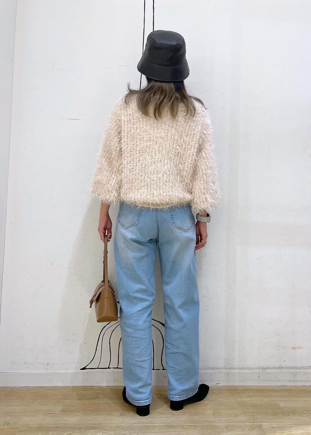 グレー系のタンクトップ、ブルー系のデニムパンツ、ベージュ系のカーディガン/ボレロを着用したレディースの秋コーディネートの5枚目の写真