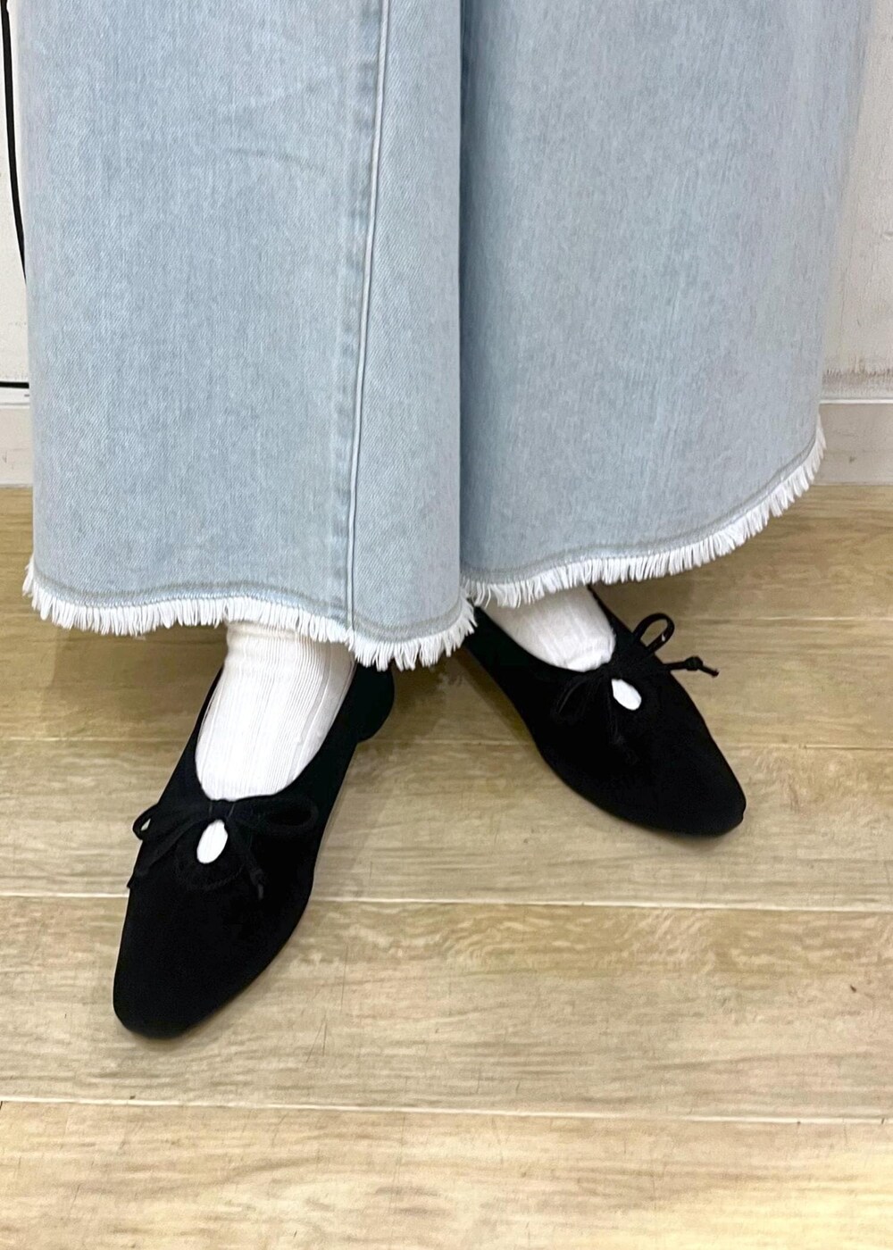 ホワイト系のニット/セーター、ブラック系のパンプス、ブルー系のデニムスカートを着用したレディースの冬コーディネートの10枚目の写真