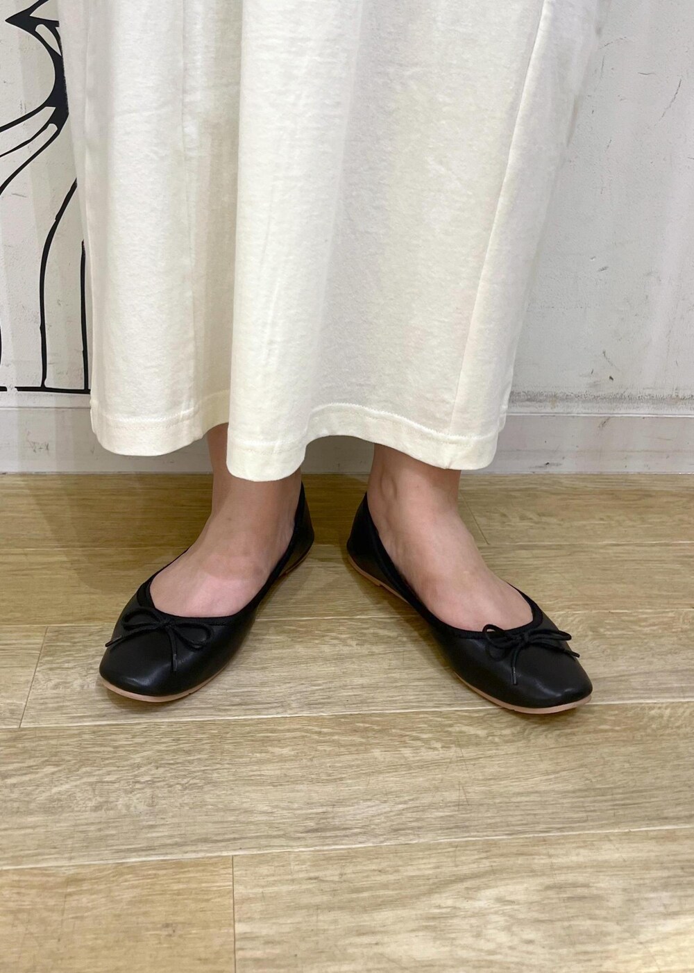 ブラック系のトートバッグ、ブラック系のバレエシューズ、ホワイト系のワンピースを着用したレディースの夏コーディネートの10枚目の写真