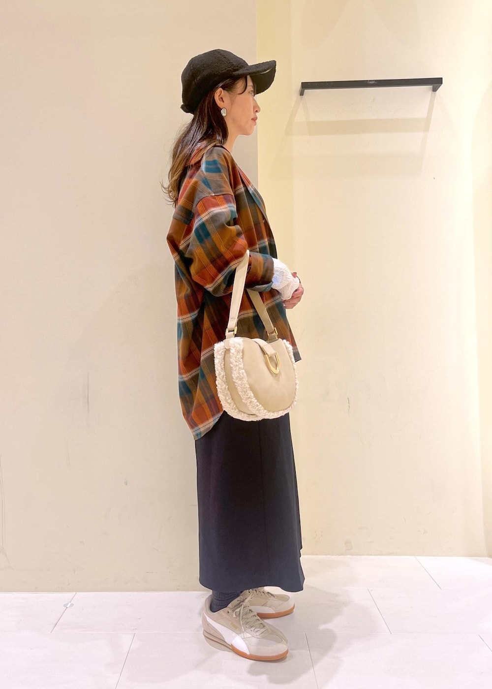 ブルー系のスカート、オレンジ系のシャツ/ブラウス、ホワイト系のTシャツ/カットソーを着用したレディースの秋コーディネートの2枚目の写真