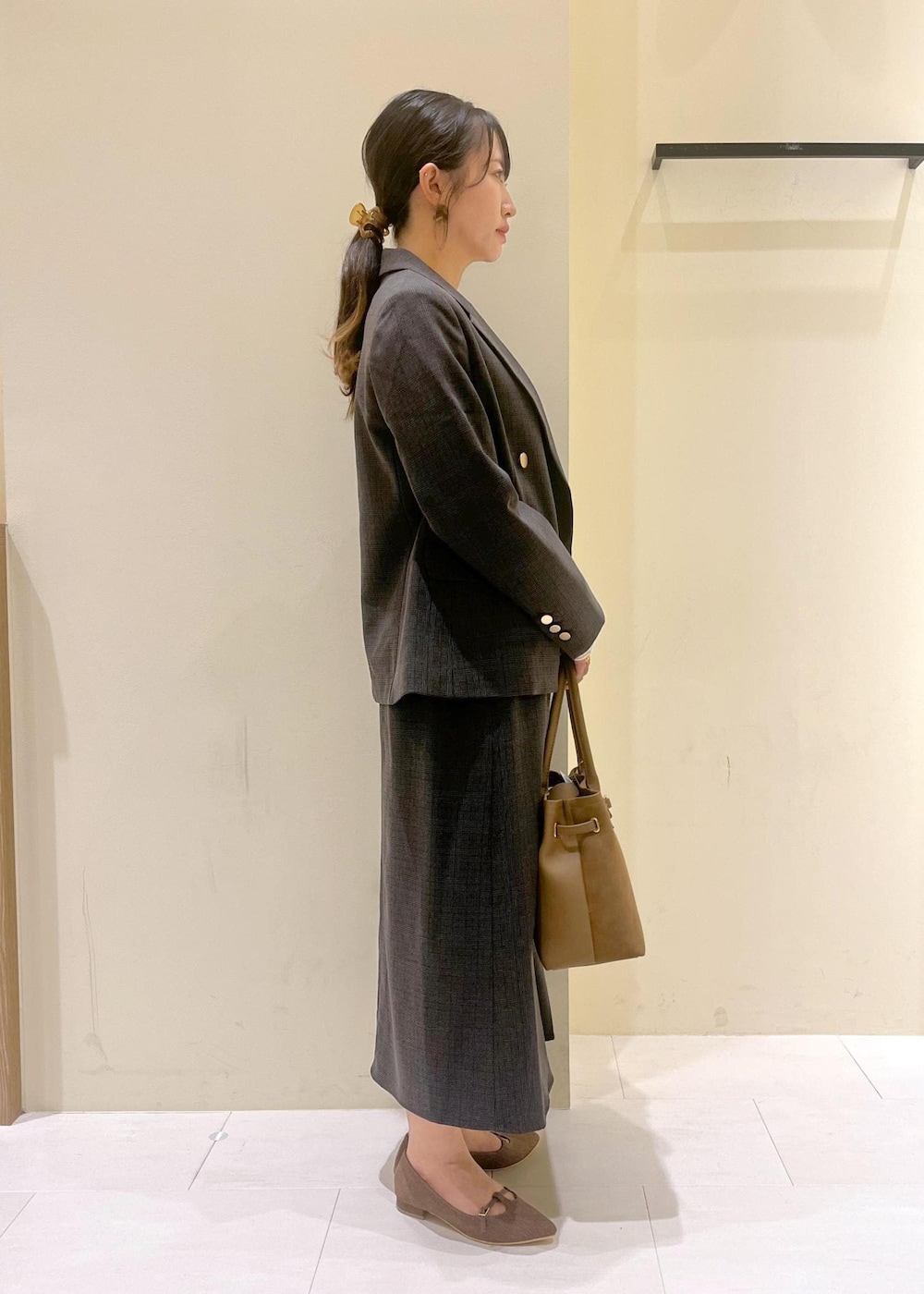 ブラック系のスカート、ブラック系のテーラードジャケット、ホワイト系のTシャツ/カットソーを着用したレディースの秋コーディネートの3枚目の写真