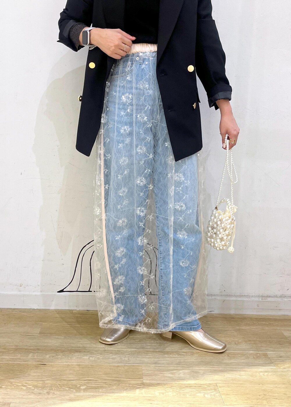 ホワイト系のスカート、ブラック系のニット/セーター、ブラック系のテーラードジャケットを着用したレディースの秋コーディネートの8枚目の写真