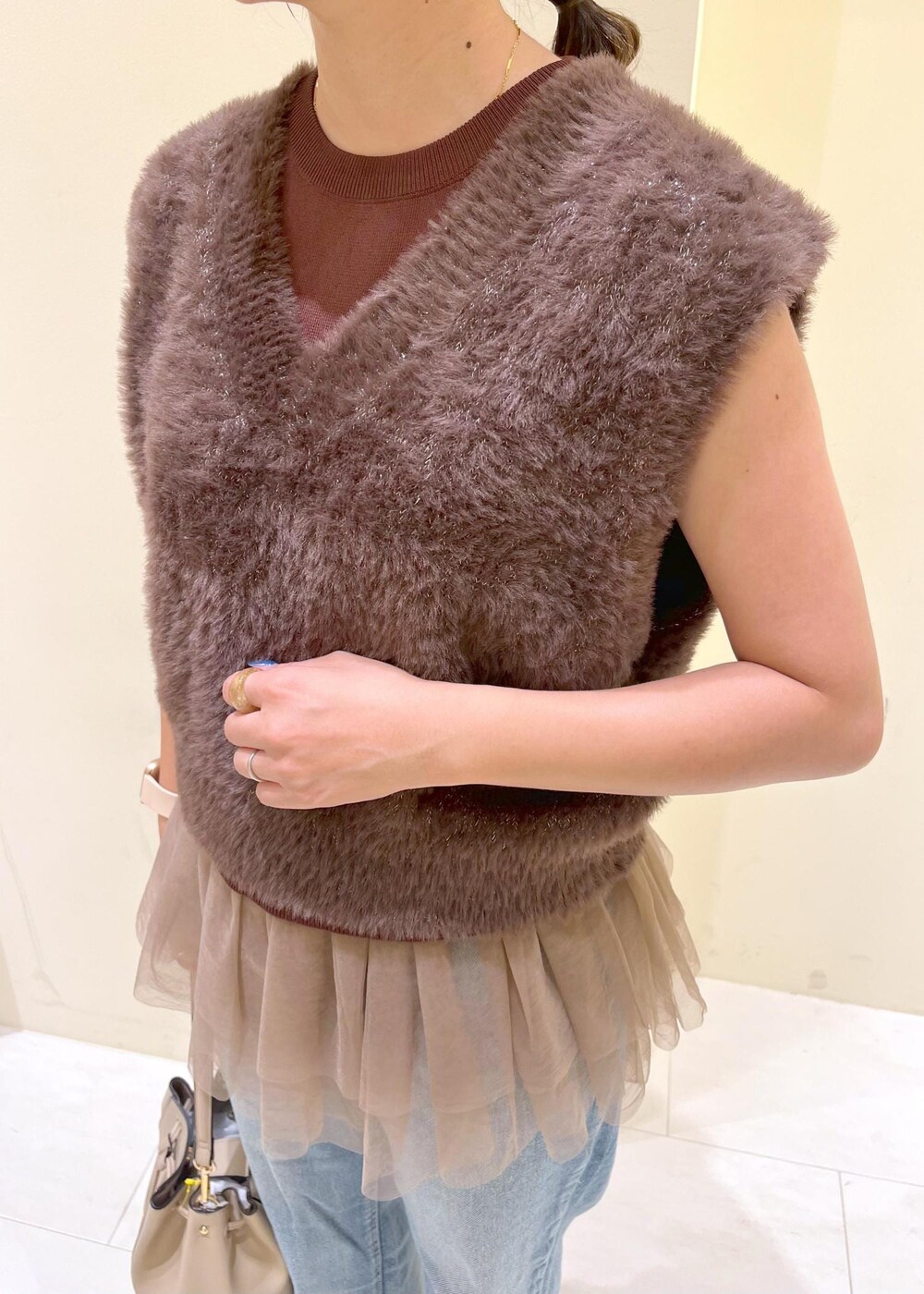 グレー系のローファー、ブルー系のデニムパンツ、ベージュ系のショルダーバッグを着用したレディースの夏コーディネートの5枚目の写真