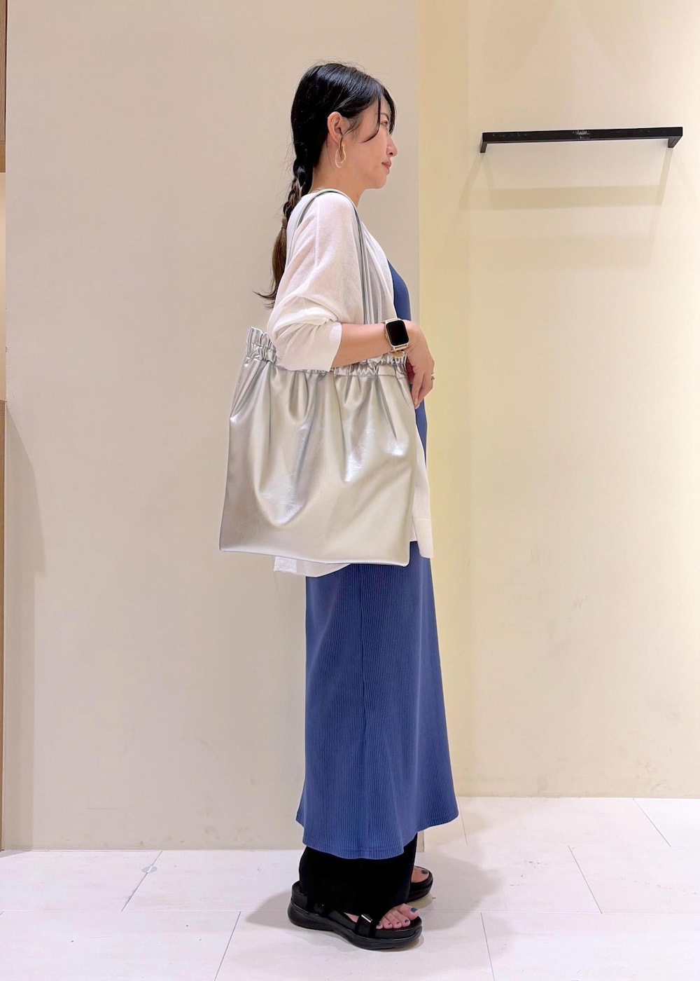 ブラック系のその他パンツ、ブルー系のワンピース、ホワイト系のカーディガン/ボレロを着用したレディースの春コーディネートの3枚目の写真