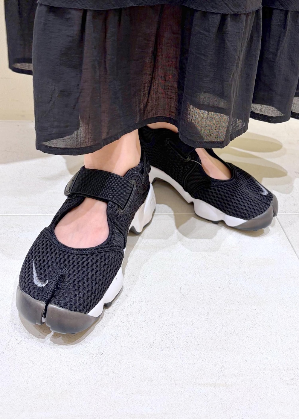 グレー系のショルダーバッグ、ブラック系のスカート、ブルー系のシャツ/ブラウスを着用したレディースの夏コーディネートの10枚目の写真