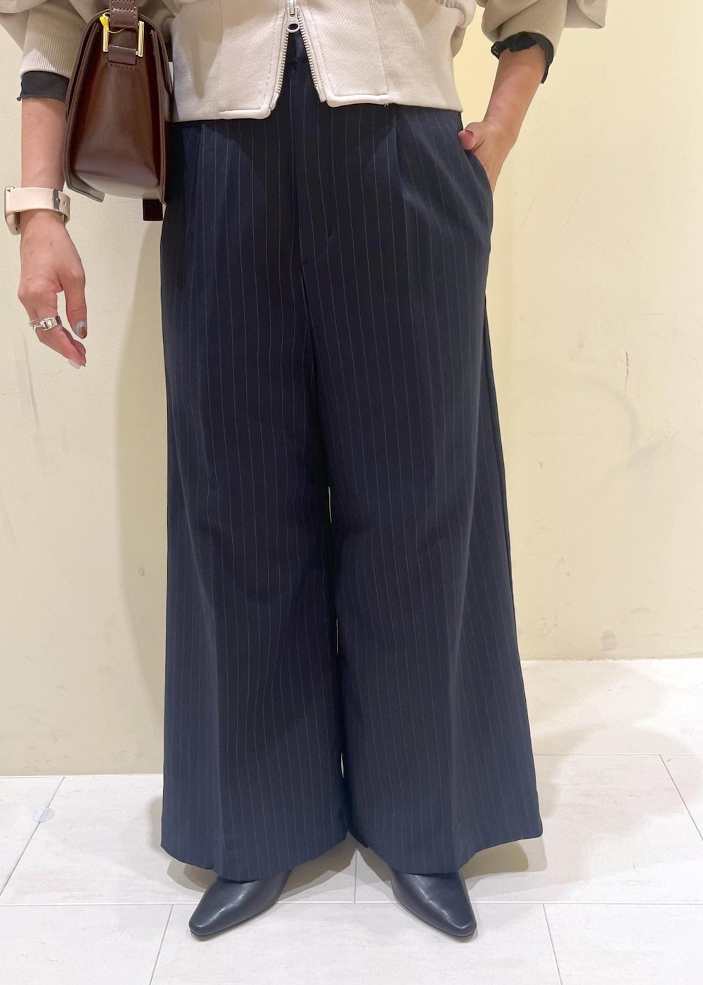 レッド系のショルダーバッグ、ブルー系のその他パンツ、ブラック系のTシャツ/カットソーを着用したレディースの秋コーディネートの8枚目の写真