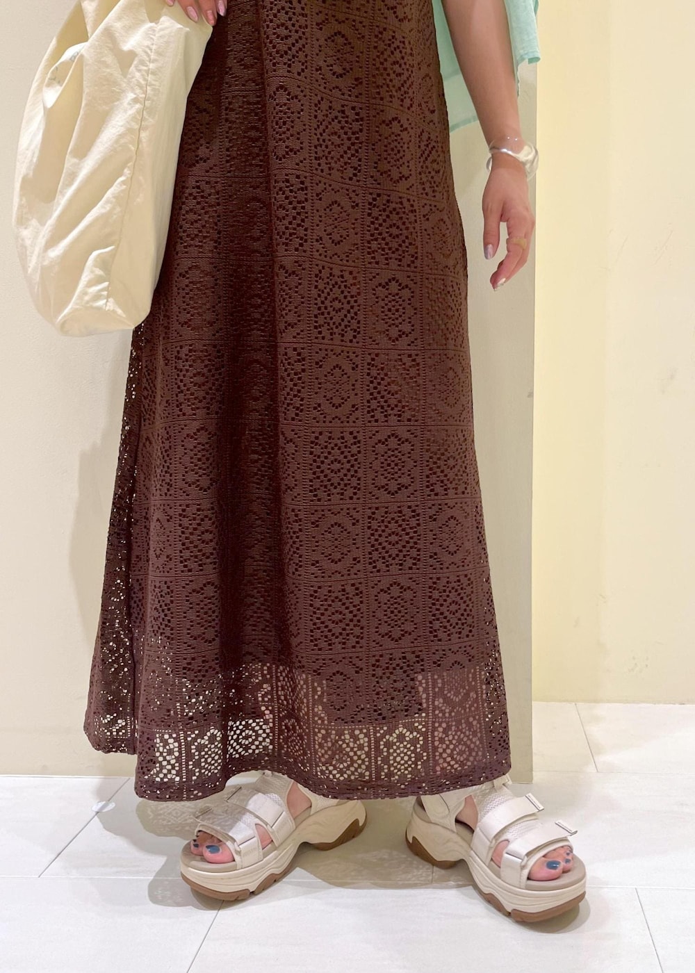 ブラック系のタンクトップ、グリーン系のシャツ/ブラウス、ホワイト系のトートバッグを着用したレディースの夏コーディネートの9枚目の写真