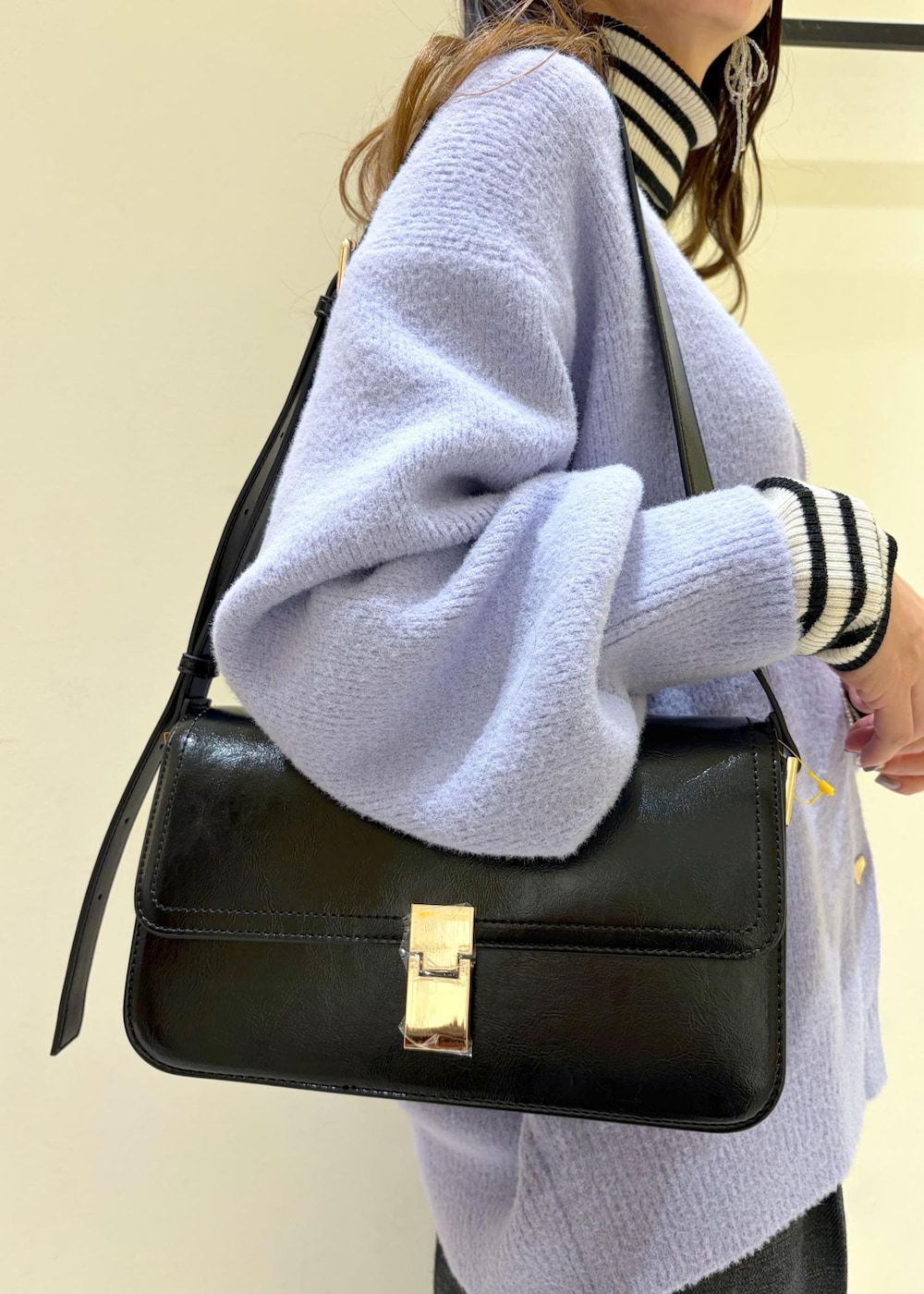 ブラック系のショルダーバッグ、ホワイト系のニット/セーター、グレー系のスラックスを着用したレディースの冬コーディネートの8枚目の写真