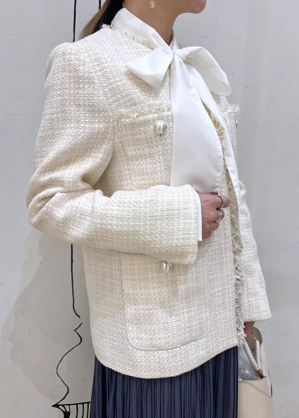 ホワイト系のショルダーバッグ、ブルー系のスカート、ベージュ系のローファーを着用したレディースの冬コーディネートの6枚目の写真