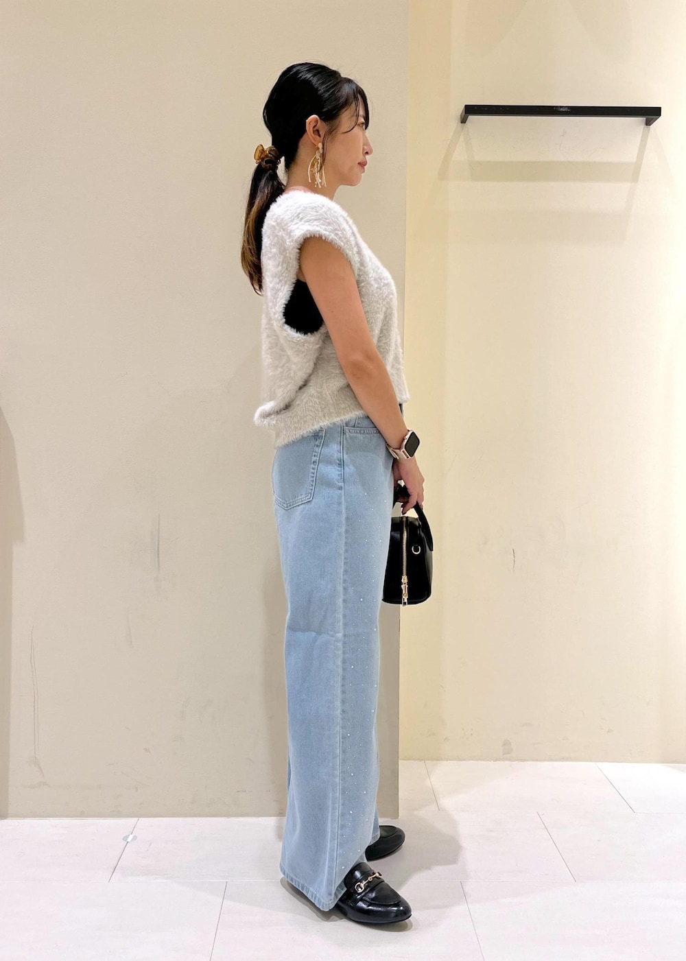 ブルー系のデニムパンツ、グレー系のベスト、ブラック系のローファーを着用したレディースの秋コーディネートの2枚目の写真