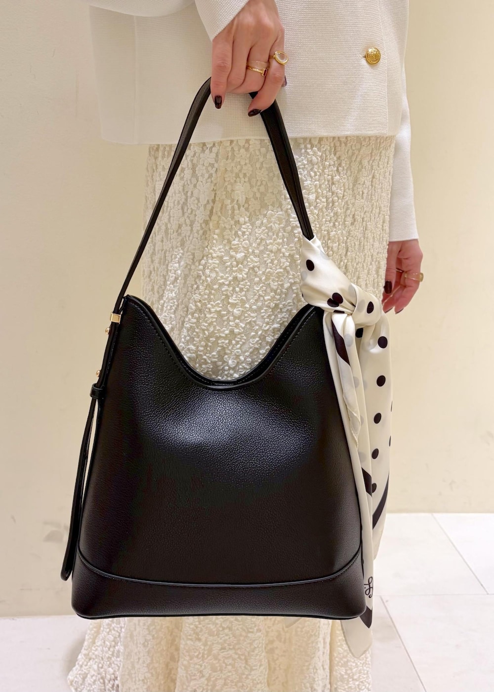 ブラック系のショルダーバッグ、ホワイト系のカーディガン/ボレロ、ホワイト系のスカートを着用したレディースの冬コーディネートの8枚目の写真