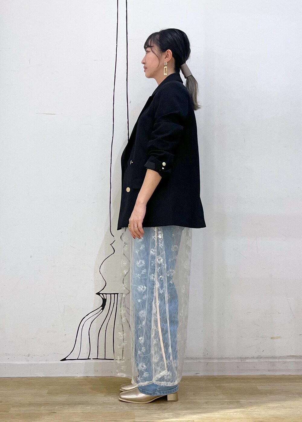 ホワイト系のスカート、ブラック系のニット/セーター、ブラック系のテーラードジャケットを着用したレディースの秋コーディネートの5枚目の写真