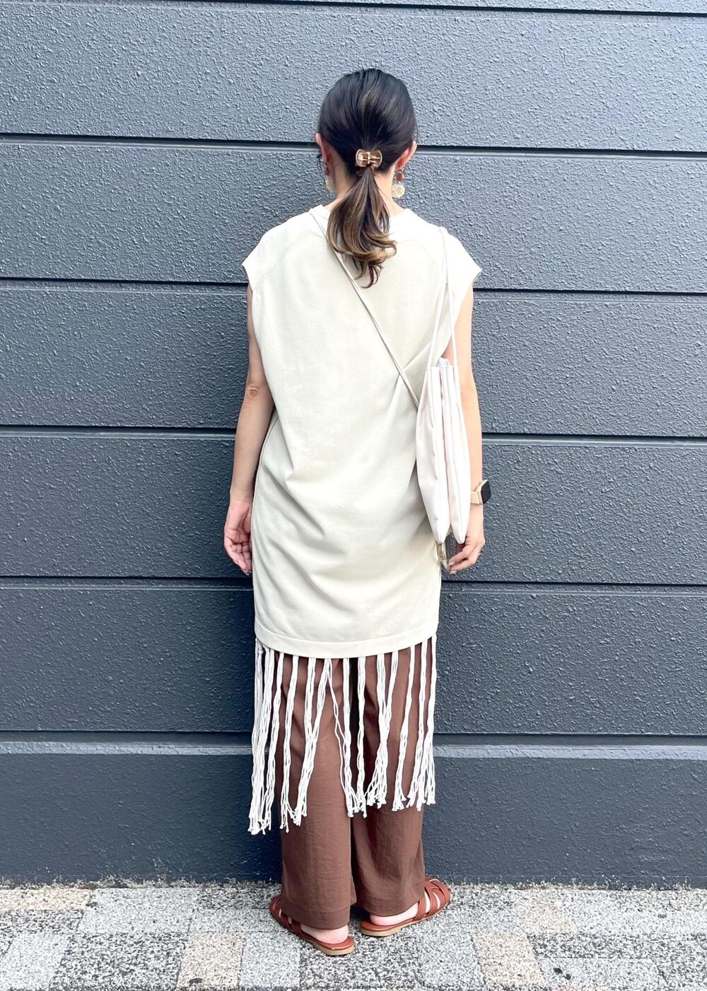 ホワイト系のトートバッグ、ホワイト系のスカート、ブラウン系のその他パンツを着用したレディースの夏コーディネートの4枚目の写真