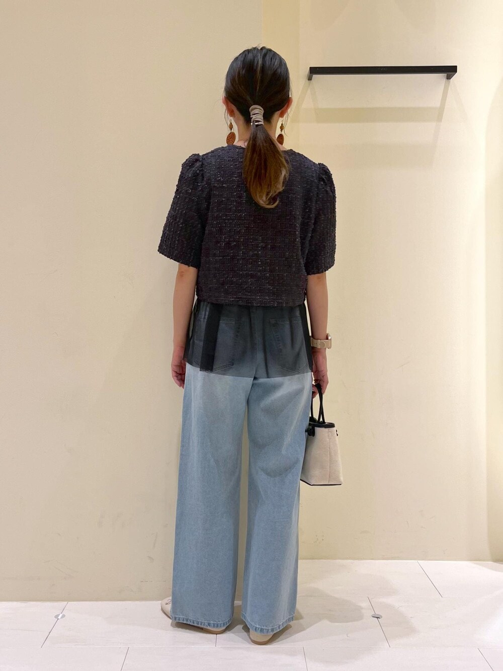 ブルー系のデニムパンツ、ホワイト系のバレエシューズ、グレー系のノーカラージャケットを着用したレディースの春コーディネートの4枚目の写真