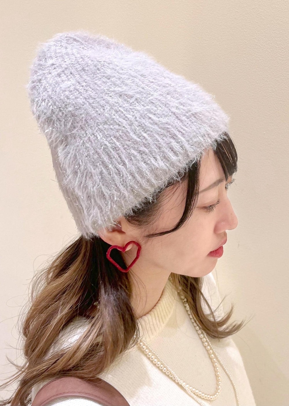 ホワイト系のニット/セーター、ブラウン系のショルダーバッグ、ブラウン系のローファーを着用したレディースの冬コーディネートの4枚目の写真