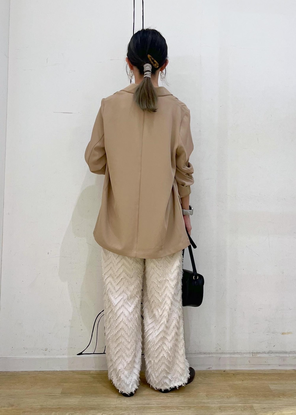 ベージュ系のタンクトップ、ブラック系のショルダーバッグ、ベージュ系のその他パンツを着用したレディースの秋コーディネートの5枚目の写真