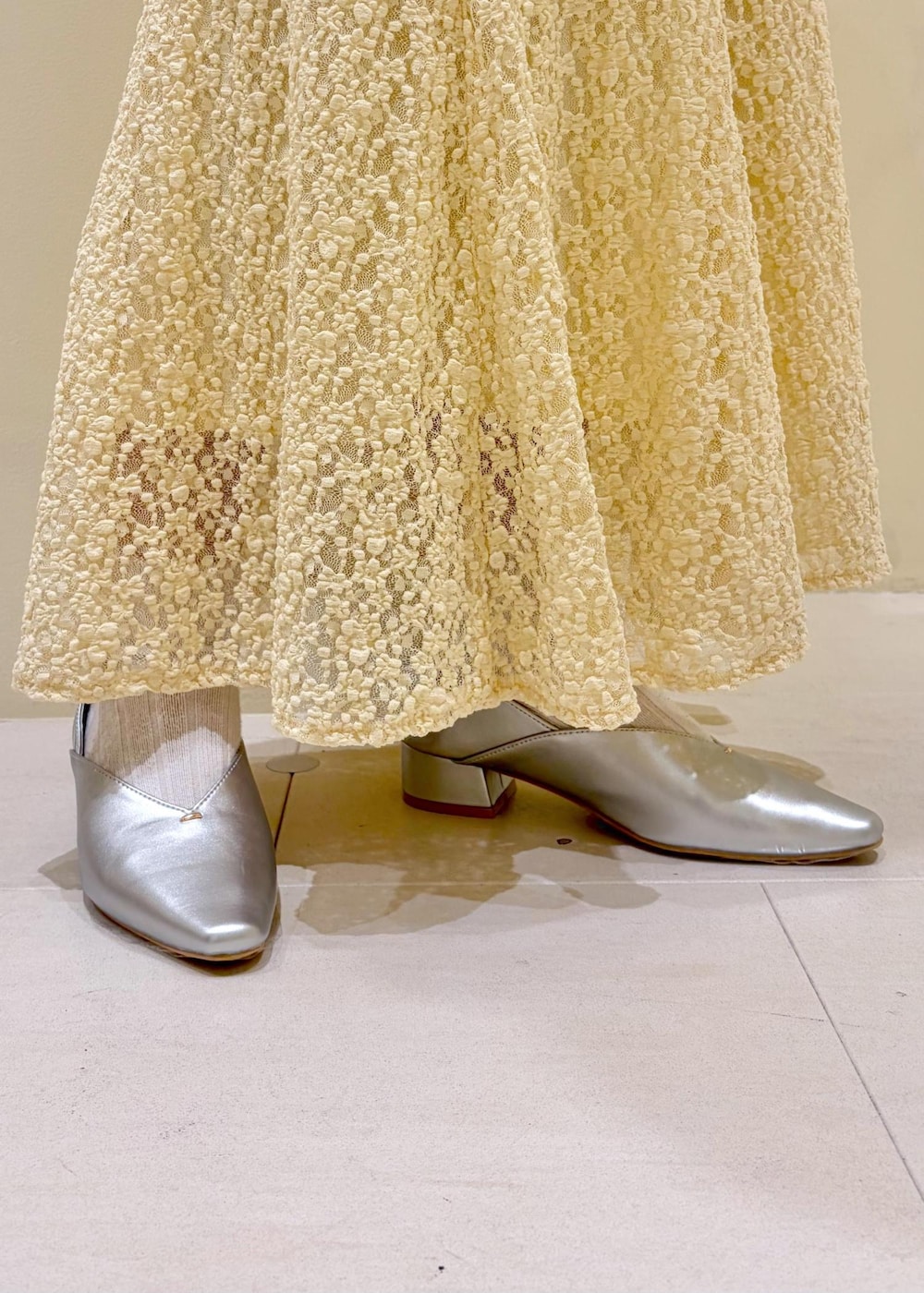 ホワイト系のボストンバッグ、ベージュ系のスカート、ブラウン系のカーディガン/ボレロを着用したレディースの春コーディネートの10枚目の写真