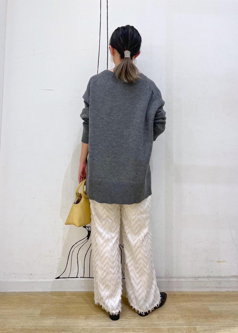 グレー系のタンクトップ、ブラック系のパンプス、イエロー系のショルダーバッグを着用したレディースの夏コーディネートの7枚目の写真