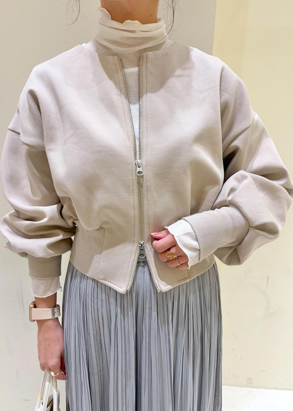 グレー系のスカート、ベージュ系のカーディガン/ボレロ、ホワイト系のトートバッグを着用したレディースの冬コーディネートの6枚目の写真