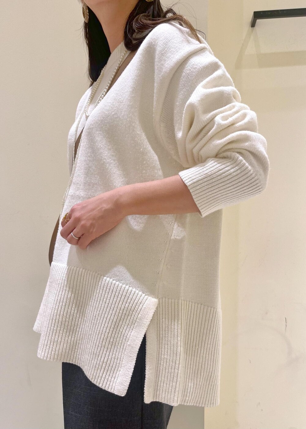 ホワイト系のニット/セーター、グレー系のスラックス、ブラウン系のローファーを着用したレディースの冬コーディネートの7枚目の写真