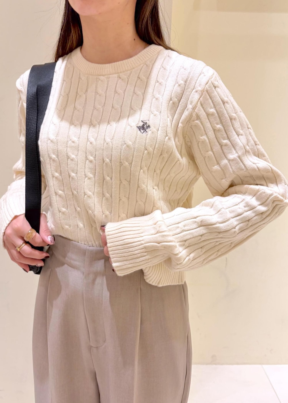 ホワイト系のニット/セーター、ベージュ系のその他パンツ、ブラック系のボディバッグ/ウエストポーチを着用したレディースの冬コーディネートの5枚目の写真