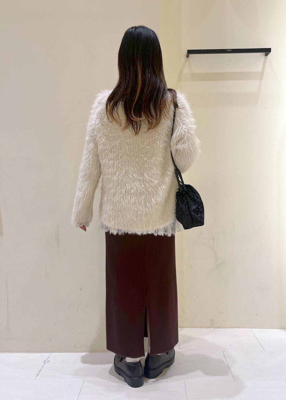 ホワイト系のTシャツ/カットソー、ブラック系のローファー、ブラック系のハンドバッグを着用したレディースの冬コーディネートの3枚目の写真