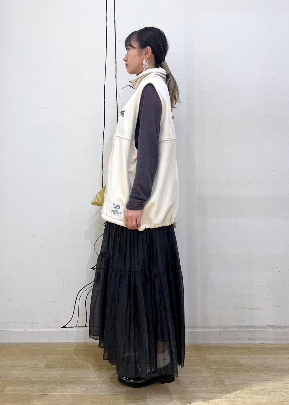 グレー系のTシャツ/カットソー、ブラック系のレインシューズ、イエロー系のショルダーバッグを着用したレディースの秋コーディネートの3枚目の写真