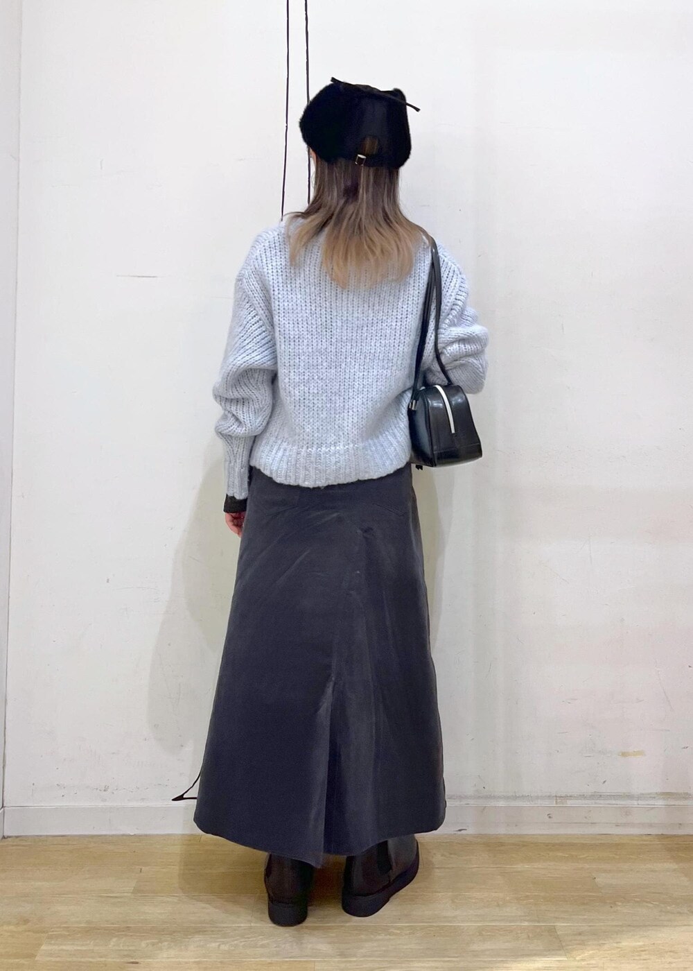 ブラック系のニット/セーター、ブラック系のブーツ、ブラック系のボストンバッグを着用したレディースの冬コーディネートの5枚目の写真