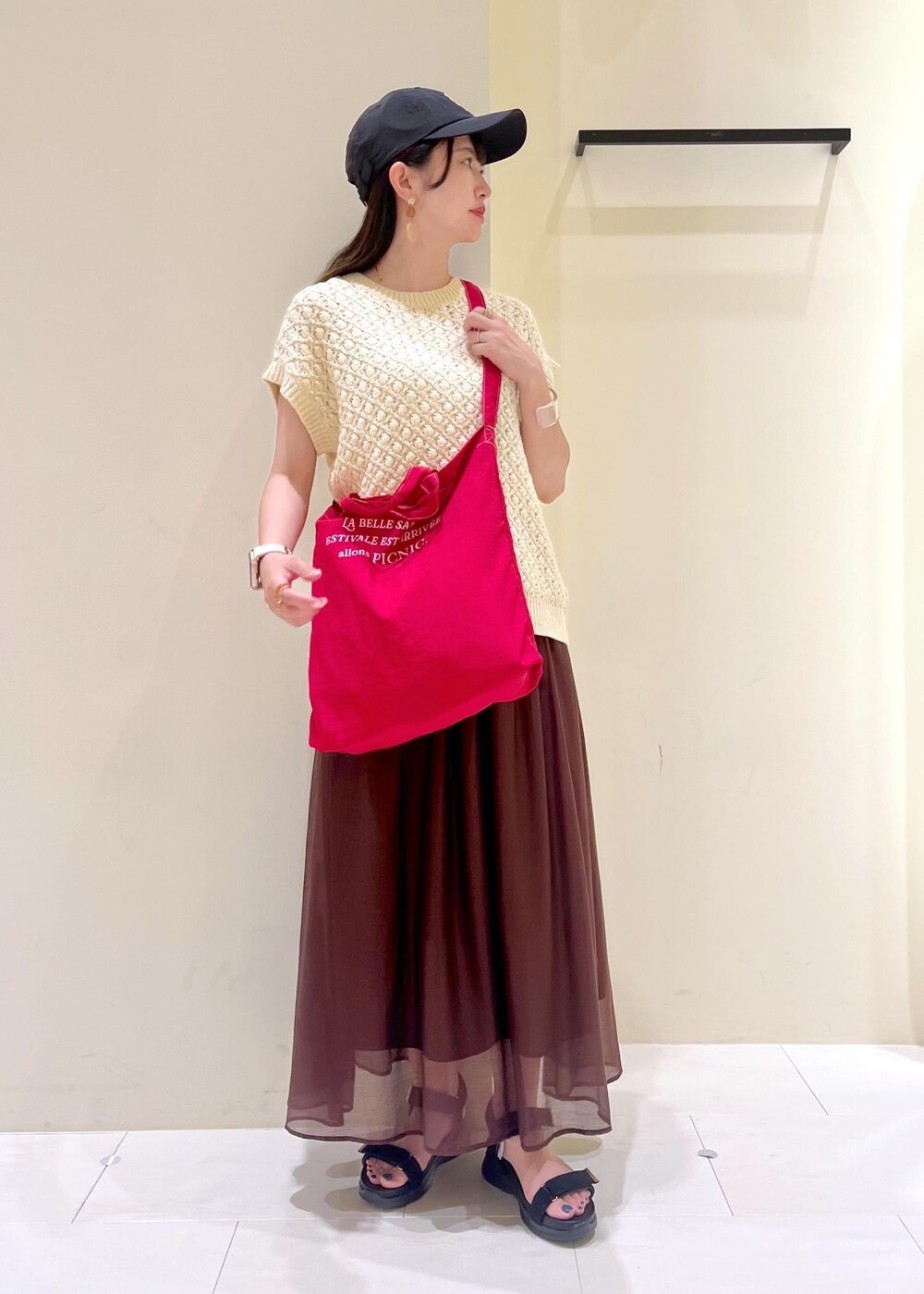 ブラック系のサンダル、ブラウン系のスカート、ベージュ系のベストを着用したレディースの夏コーディネートの2枚目の写真