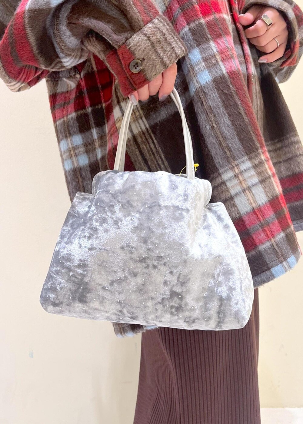 ブラック系のブーツ、ホワイト系のニット/セーター、シルバー系のハンドバッグを着用したレディースの冬コーディネートの9枚目の写真