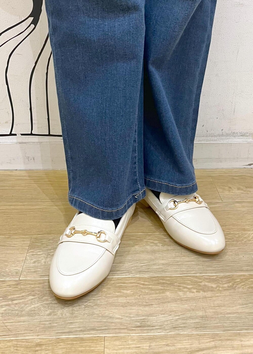 ピンク系のニット/セーター、ホワイト系のハンドバッグ、ブルー系のデニムパンツを着用したレディースの冬コーディネートの7枚目の写真